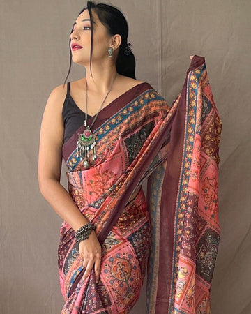Woman wearing a traditional saree with a patterned design against a neutral background